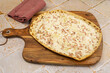 flammekueche (tarte flambée), spécialité alsacienne,  sur une planche à découper