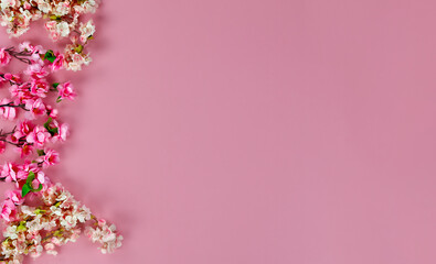 Sticker - Overhead view of left side border of cherry blossoms on pink background for Mothers Day or Easter holiday