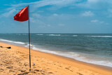 Fototapeta Fototapety z morzem do Twojej sypialni - Czerwona flaga na tropikalnej plaży, widok na ocean.