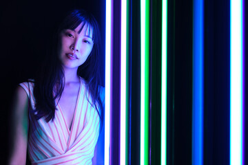 Young asian woman pose with colorful bright neon lights in studio.