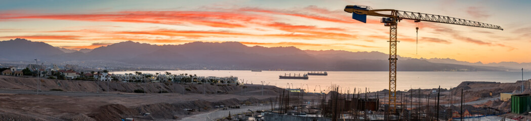 Wall Mural - Panoramic aerial view on construction site and the gulf of Aqaba at dawn