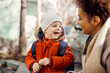 © Dusan Petkovic - Caregiver laughing with kindergarten child in the schoolyard. Happy kindergarten child laughing and looking at his caregiver while standing at the schoolyard.
