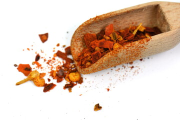 Wall Mural - Red Hot Cayenne pepper in a wooden scoop isolated. Pile crushed red cayenne pepper, dried chili flakes and seeds isolated on white background