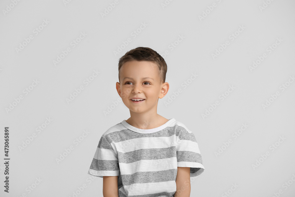 Portrait of happy little boy on light background