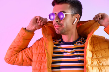 Wall Mural - Stylish young man in sunglasses and yellow jacket on color background, closeup