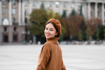 Canvas Print - Beautiful smiling woman in beret hat on city street