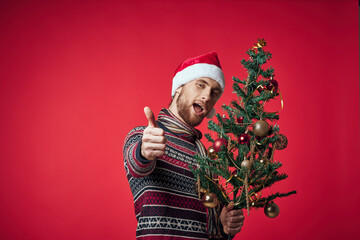 Wall Mural - Cheerful man in a santa hat Christmas decorations holiday New Year red background