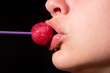 Close up, model with lips touching a red lollipop