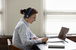 © fizkes - Happy elder student in headphones watching learning webinar on laptop, virtual workshop, writing notes. Getting knowledge, new profession, studying online from home, taking e-learning course
