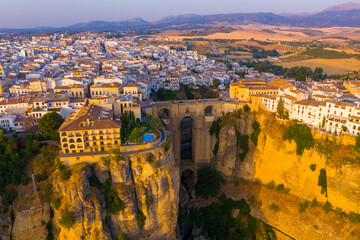 Wall Mural - Ronda, Spain. Aerial evening view of New Bridge over Guadalevin River in Ronda, Andalusia, Spain. View of the touristic city with arena at the background