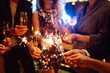 © maxbelchenko - Sparkling sparklers in the hands of young friends. People  celebrate winter holidays with sparkles and champagne. Holidays, vacation, relax, party and lifestyle concept.