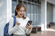 © David - Portrait of young student girl, Excited student checking smartphone content in a campus,The study, education, university, college, graduate concept