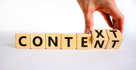 Content and context symbol. Businessman turns wooden cubes and changes the word context to content. Beautiful white table, white background. Business and content and context concept. Copy space.