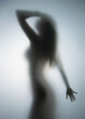 Beautiful perfect body woman stands behind a wet bathroom glass wall, Body silhouette.
