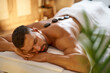 Relaxed man enjoying hot stones massage