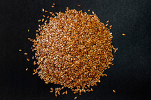 Flax Grains On A Black Background. Healthy Seeds. A Handful Of Seeds.