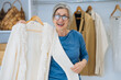 © teksomolika - Elderly woman during chooses white sweater at home