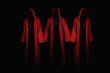 Group of mystery people in a red hooded cloaks.  Unrecognizable person. Hiding face in shadow. Ghostly figure. Satanic sect member. Conspiracy concept. Isolated on black.