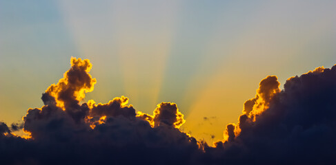 Wall Mural - Background from a beautiful sunset with clouds and sunlights over mountanous coast. High quality photo