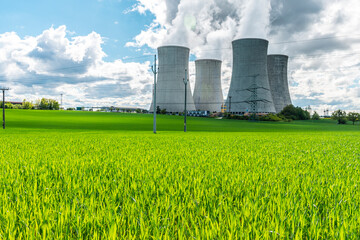 Cooling tower of nuclear power plant behind green grass. Atomic energy. Nuclear power and the environment.