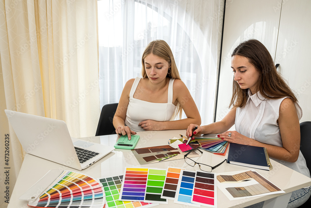 Two female designers working with house paln and color palette ...