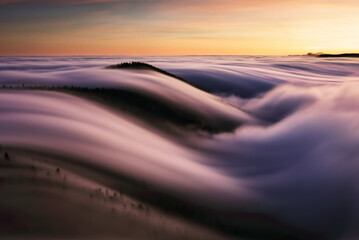 Wall Mural - mountain landscape above clouds at sunset in slovakia with forest and sun