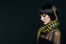 Beauty Woman Short Haircut Python Yellow Snake On Her Neck. A Yellow Snake On The Shoulders Of A Girl. Beauty Yellow Eye Shadow Makeup, Dark Burgundy Lipstick