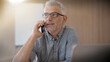 © goodluz - 40 year old man with glasses on the phone in an office