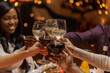 © Syda Productions - holidays, party and celebration concept - multiethnic group of happy friends having christmas dinner at home and drinking wine