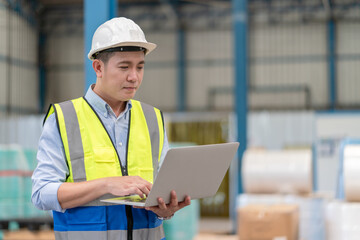 Wall Mural - Asian male supervisor engineer hold laptop working at warehouse factory