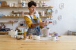 © DimaBerlin - Craftswoman examining jug cap after decorating pottery with hand drawn ornament in ceramics studio or workshop. Female ceramist creating handmade kitchenware on classes or as professional occupation