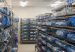 © Mint Images - Storage room in a modern hospital, rows of sterile equipment packs in blue fabric.