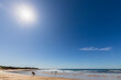 © Westend61 - Sun shining against clear blue sky over sandy coastal beach