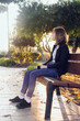 Sad teenager girl sitting on the bench in autumn park