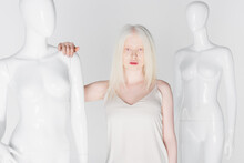 Pretty Blonde And Albino Woman Standing Near Mannequins Isolated On White.