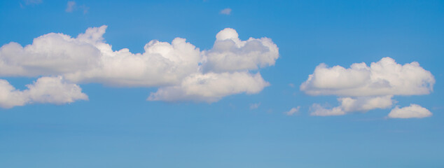 Panorama vie of white fluffy cloud floating in blue sky in sunny day, Cumulus are clouds which have flat bases and are often described as puffy, Banner design, Horizon nature background.