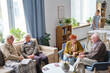 © pressmaster - Elderly people sitting on sofa talking to each other and resting while spending time in nursing home
