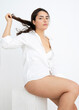 © Westend61 - Seductive woman playing with hair against white background