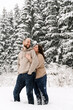 © Vadym - Walk in winter. Embracing couple enjoying snowfall. Man and woman having fun in the frosty forest. Romantic date in winter time.Christmas mood of a young family. Love and leisure concept