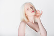 Pretty albino model in dress looking at camera isolated on white.