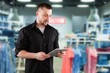 © BillionPhotos.com - Clothing Store, Merchandising Professional Uses Tablet Computer To Create Collection.