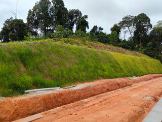 Wall Mural - Permanent slope protection with grass using the hydroseed method. The grass is used to stabilizes the slope structure and prevent slope erosion. Effective and less maintenance. 
