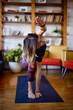 © chika_milan - A flexible yogi woman stretching and doing yoga at home. A woman in Extended Side Angle yoga pose.