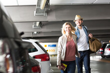Young Couple Walking Through Airport Parking Lot