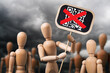 Wooden toy men with a banner in their hands against the background of a cloudy sky, the concept of protest against the introduction of QR codes