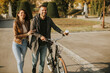 © BGStock72 - Young couple walking with bicycle in autumn park