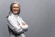 © Vadim Pastuh - Headshot of intelligent professional mature female doctor with gray hair, wearing glasses, medical white gown and stethoscope, looking at the camera, therapist physician standing isolated on gray