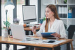 © Daenin - Asian woman sitting at a desk working in the office use a computer, laptop