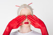 Female hands in paint covering eyes of albino model isolated on white.