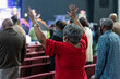 © Fitz - African American Woman Standing with Both Hands Raised in Church